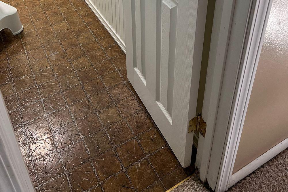 Pictured here, there is no sign that black mold is growing sporadically underneath the bathroom linoleum flooring.