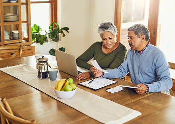 A couple reviewing documents at their dining room table.