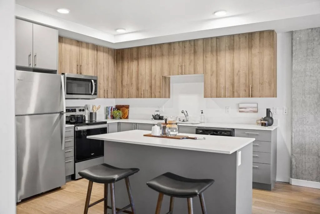 A modern kitchen with a large island and stools.