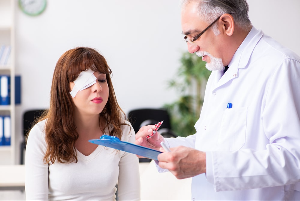 Doctor talking with female patient with patch over her right eye