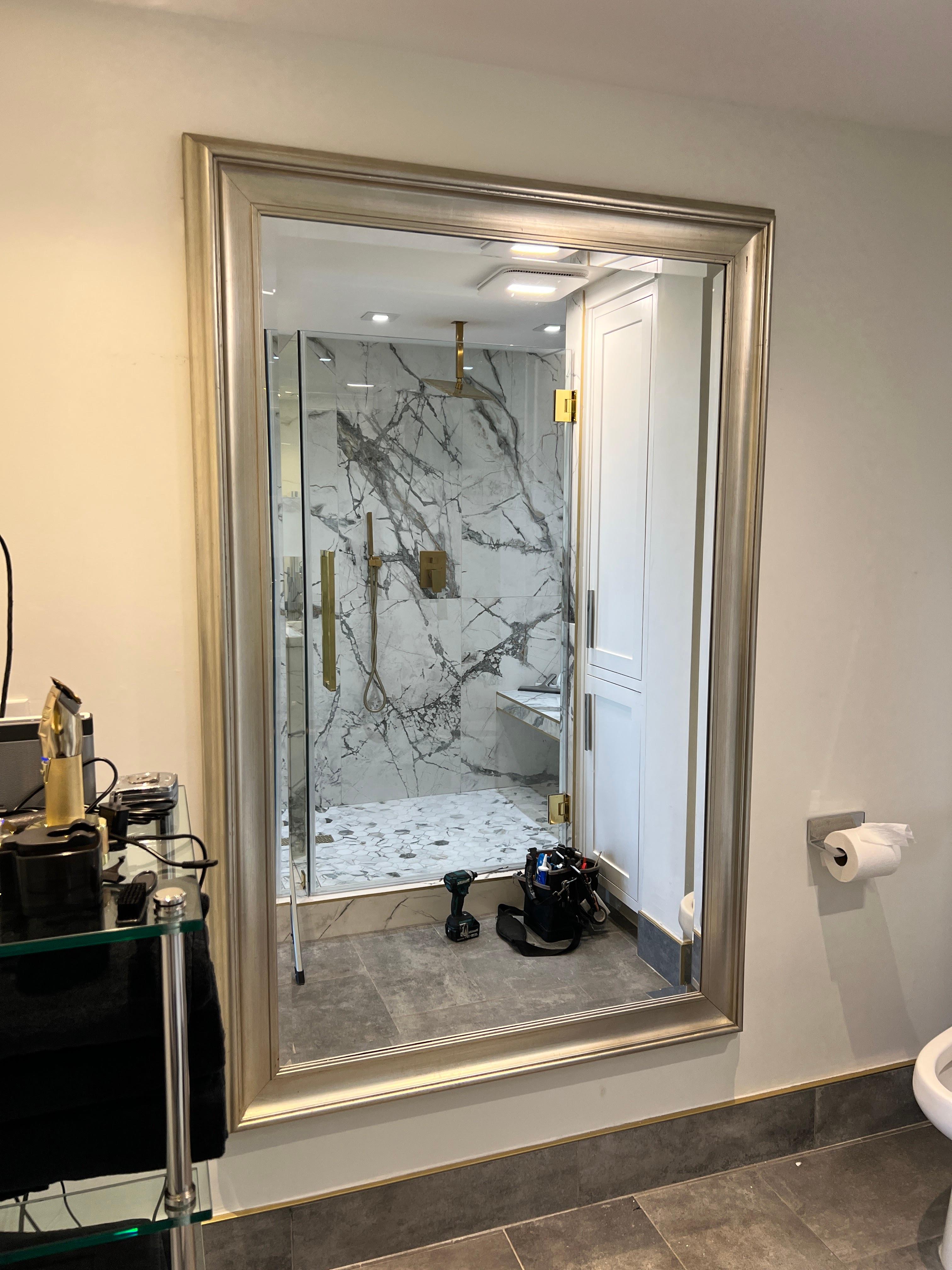 Oversized framed mirror mounted on a wall in a Houston high-rise residence.