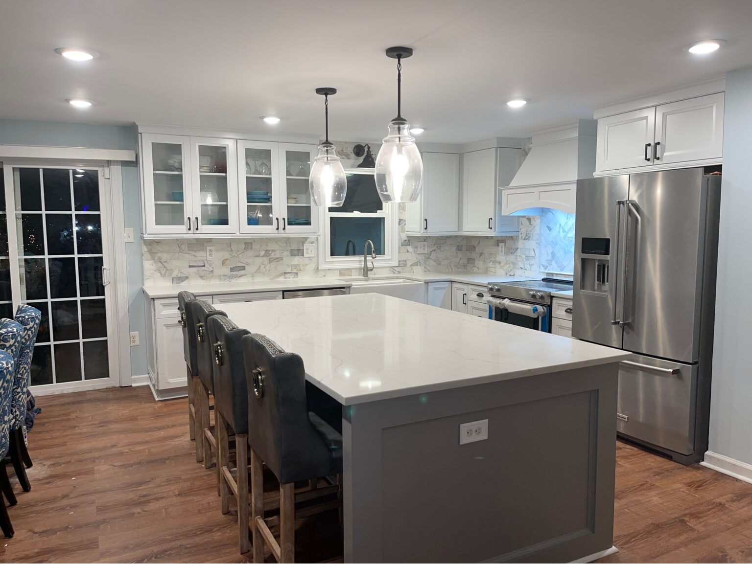 Completed kitchen remodel in Gaithersburg, MD featuring white cabinetry, quartz countertops, and pendant lighting by Elevate Remodels.