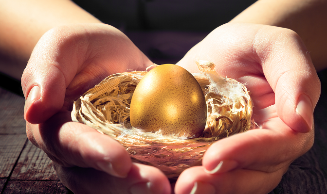 A pair of hands holding a golden goose egg.