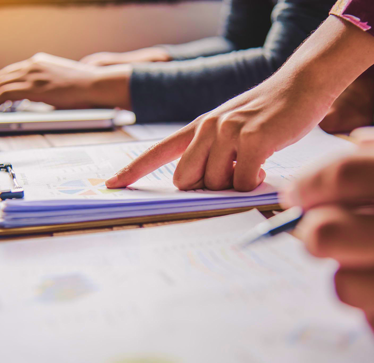 People examining papers on a table.