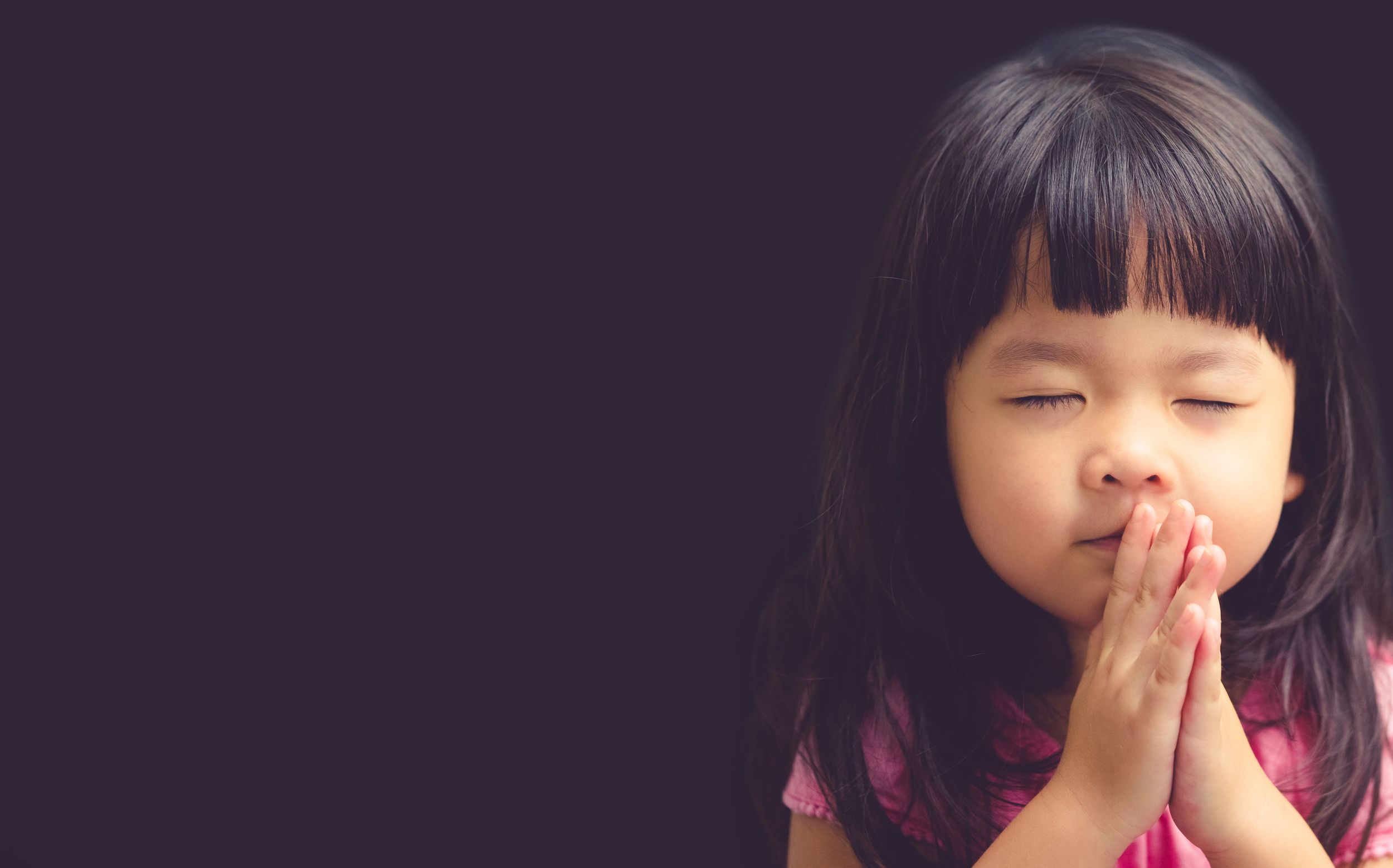 Child praying during a faith-based ministry moment