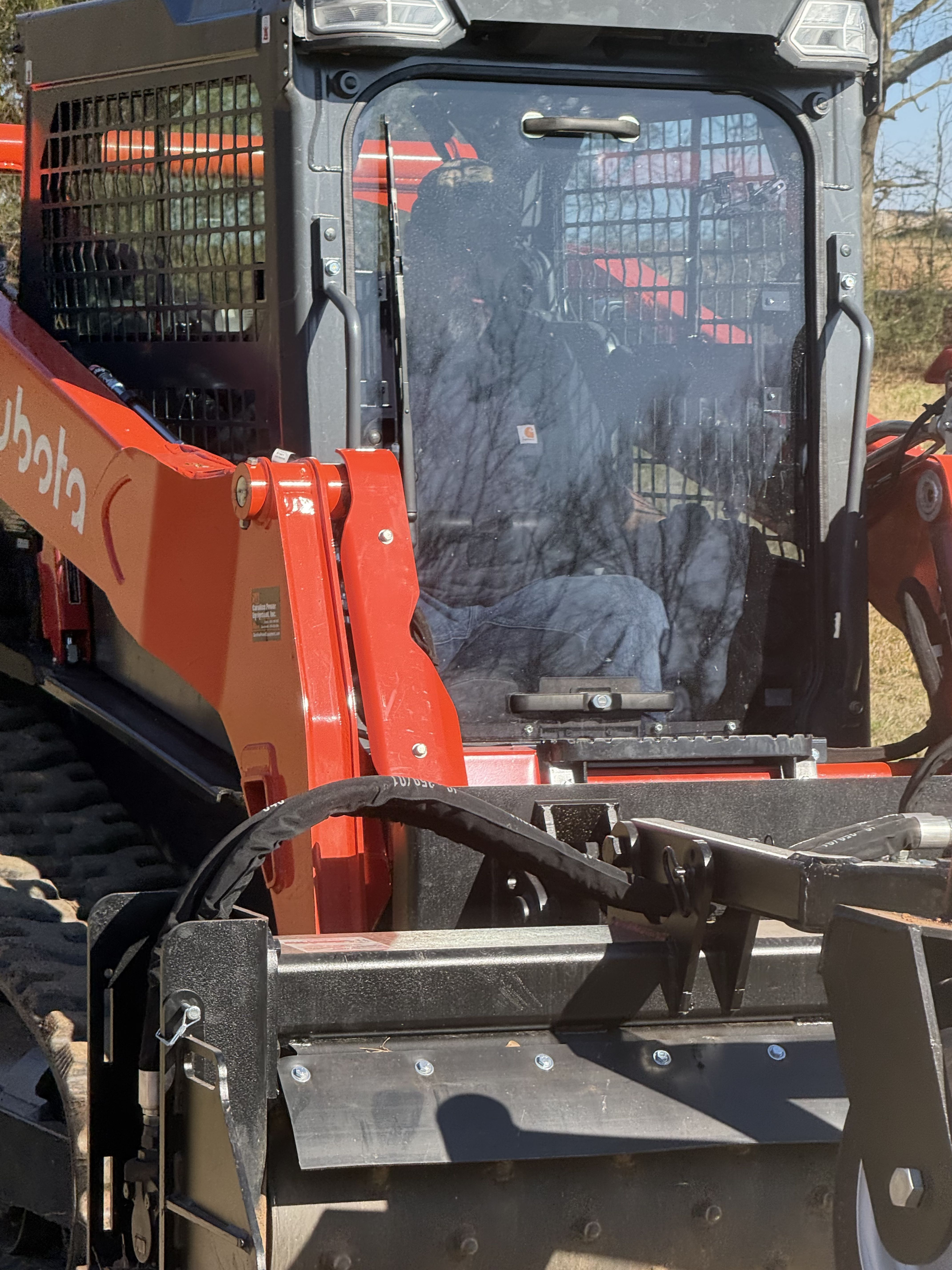 Photo of a skid steer with a land clearing attachment used for brush removal, grading, forestry mulching, and site preparation work.