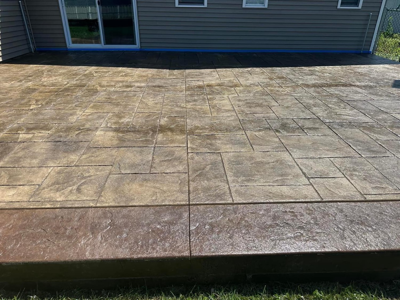 Beautiful patio with majestic Ashler slate stamp pattern. The base color is harvest wheat with a smoke release. The border is stamped with heavy stone texture and a walnut colored border
