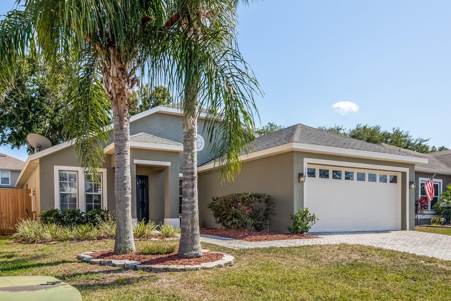 Stunning Florida home with palm trees and a two-car garage at Invitation Homes Orlando.