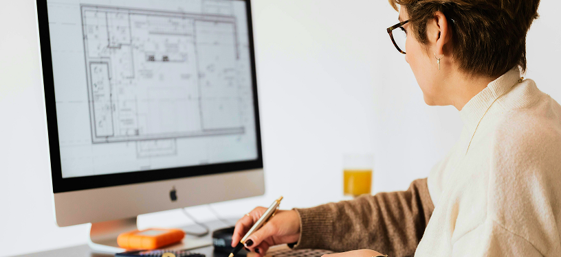 A person reviewing a floor plan on a desktop computer screen.