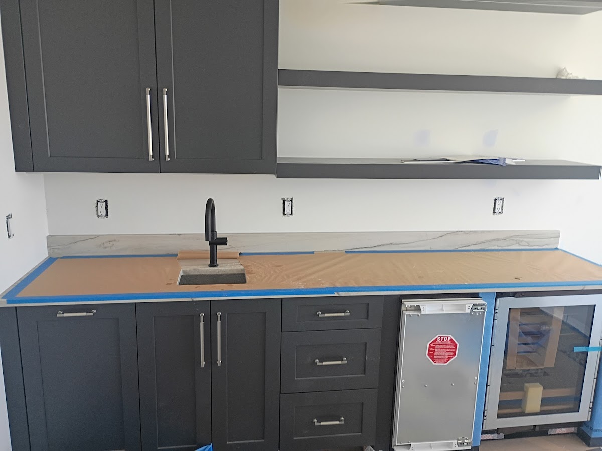 Modern kitchen sink and cabinet installation with plumbing fixtures set in place during remodeling work.