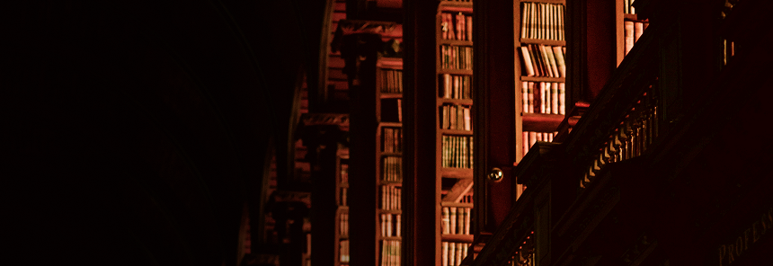 Interior shot of a traditional library with the leatherbound books in the light of the setting sun.
