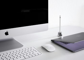 Close-up of a desktop computer, laptop, and mouse neatly organized on a desk.