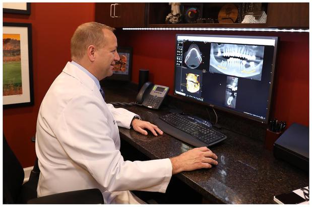 Dr. Donald G. Flynn reviewing a 3D scan for implant 
planning