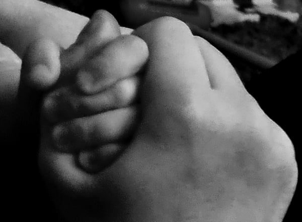 Praxis für Osteopathie am Ludwigkirchplatz & Heilpraktiker für Psychotherapie Detailaufnahme ineinanderliegender Hände als Symbol für osteopathische Behandlung, manuelle Therapie und achtsame Berührung