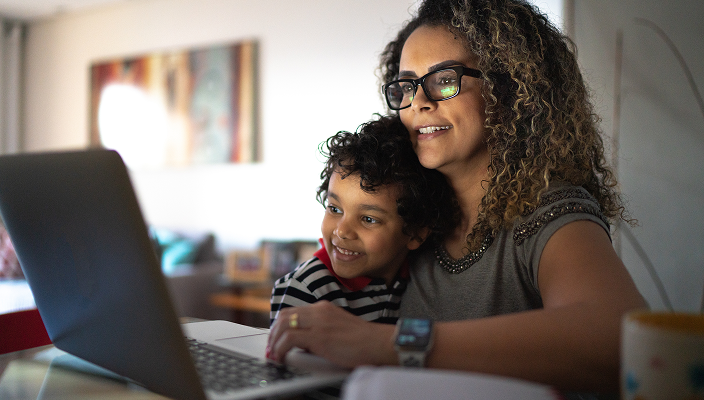 A mom and her young son looking at a laptop.