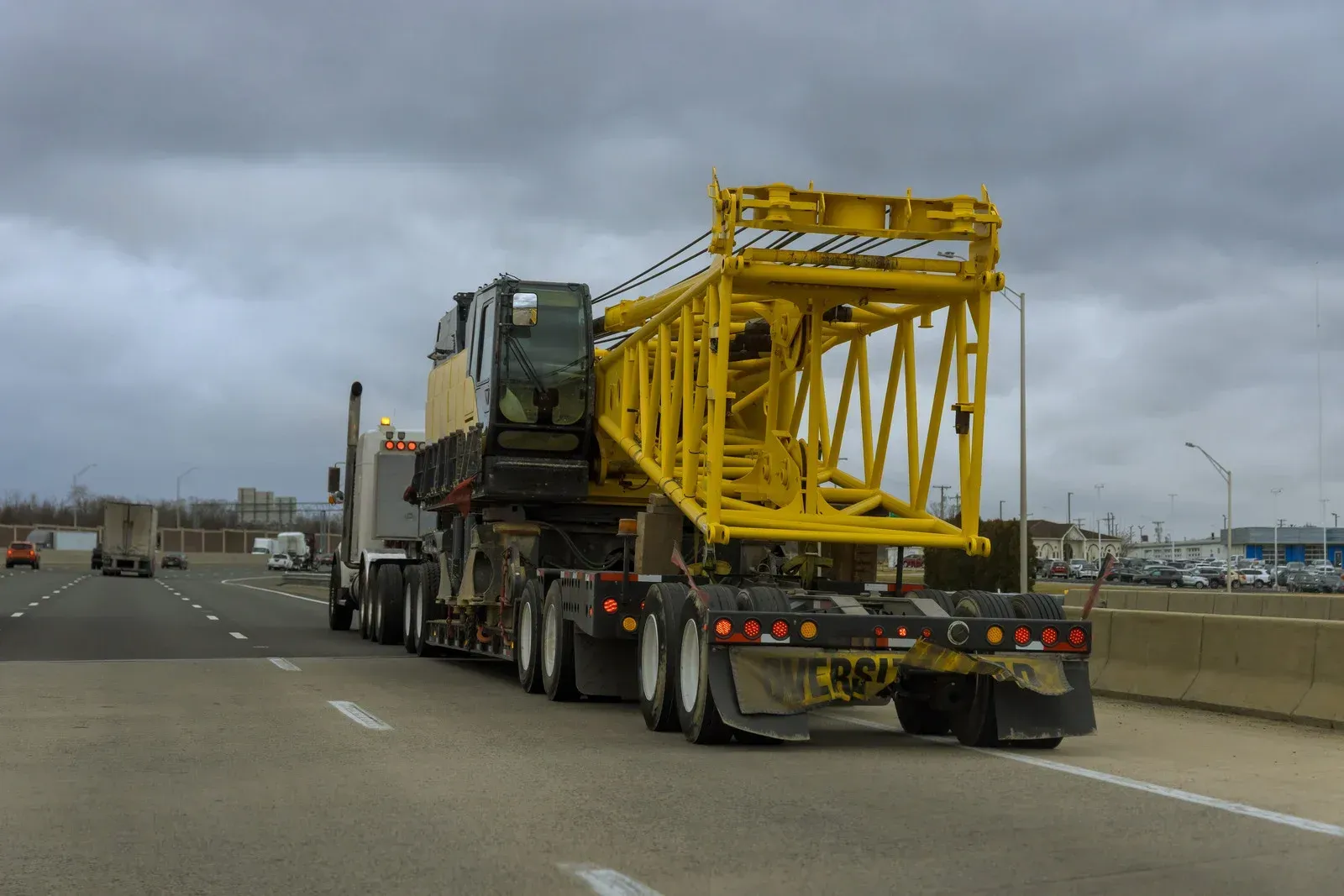 Heavy haul truck transporting a large yellow crane component on a specialized trailer. Oversized freight shipment demonstrates expertise in complex equipment transportation and industrial logistics services.