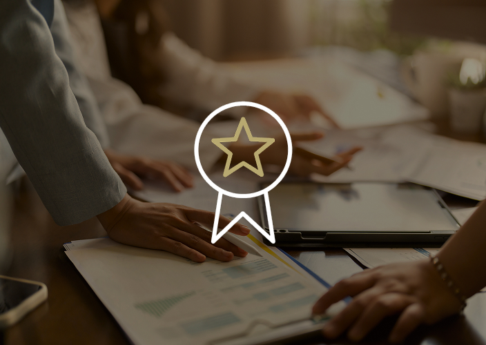 Hands resting on printed documents spread across a table.