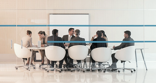 Professionals engaged in discussion in a meeting room.