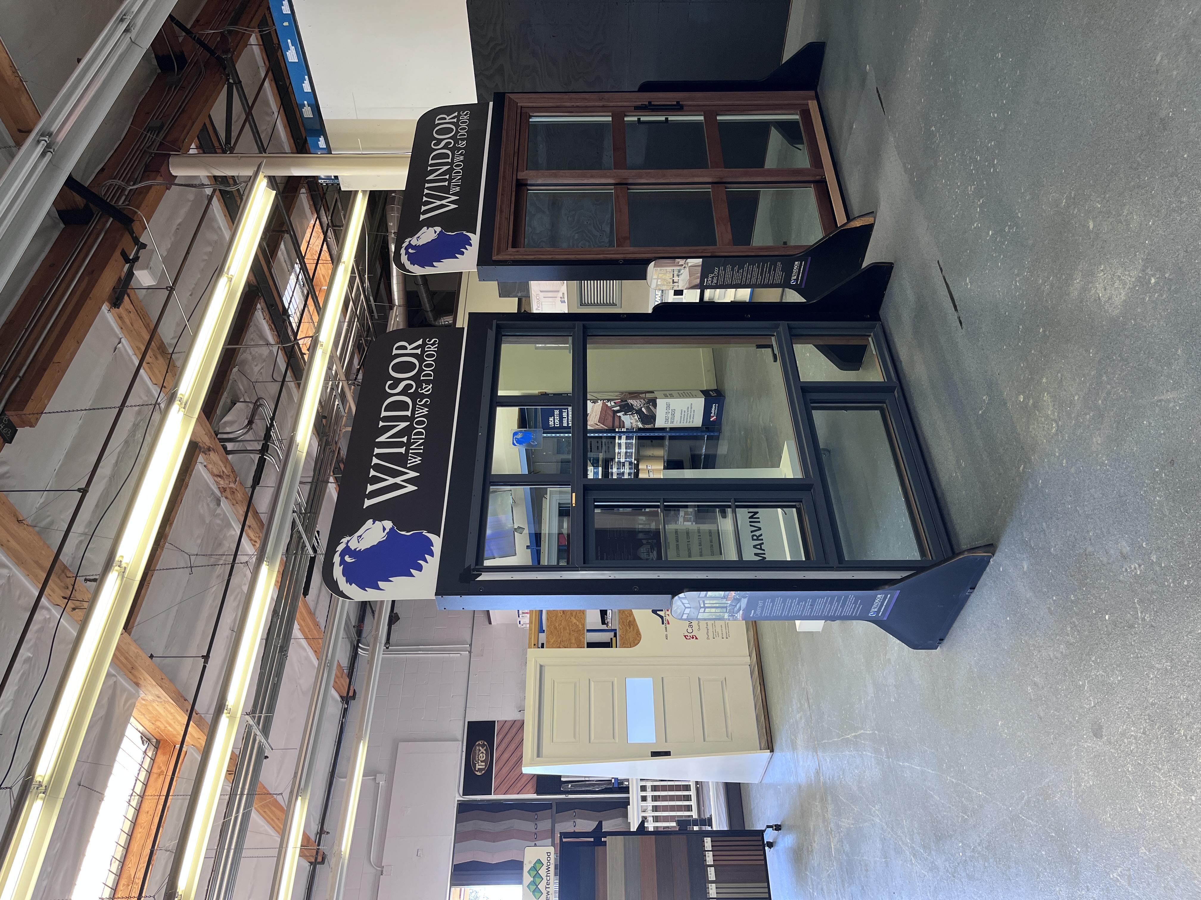 Windsor Windows & Doors showroom display at Builders FirstSource Thousand Oaks, CA, featuring a casement window and a wood-framed sliding patio door.