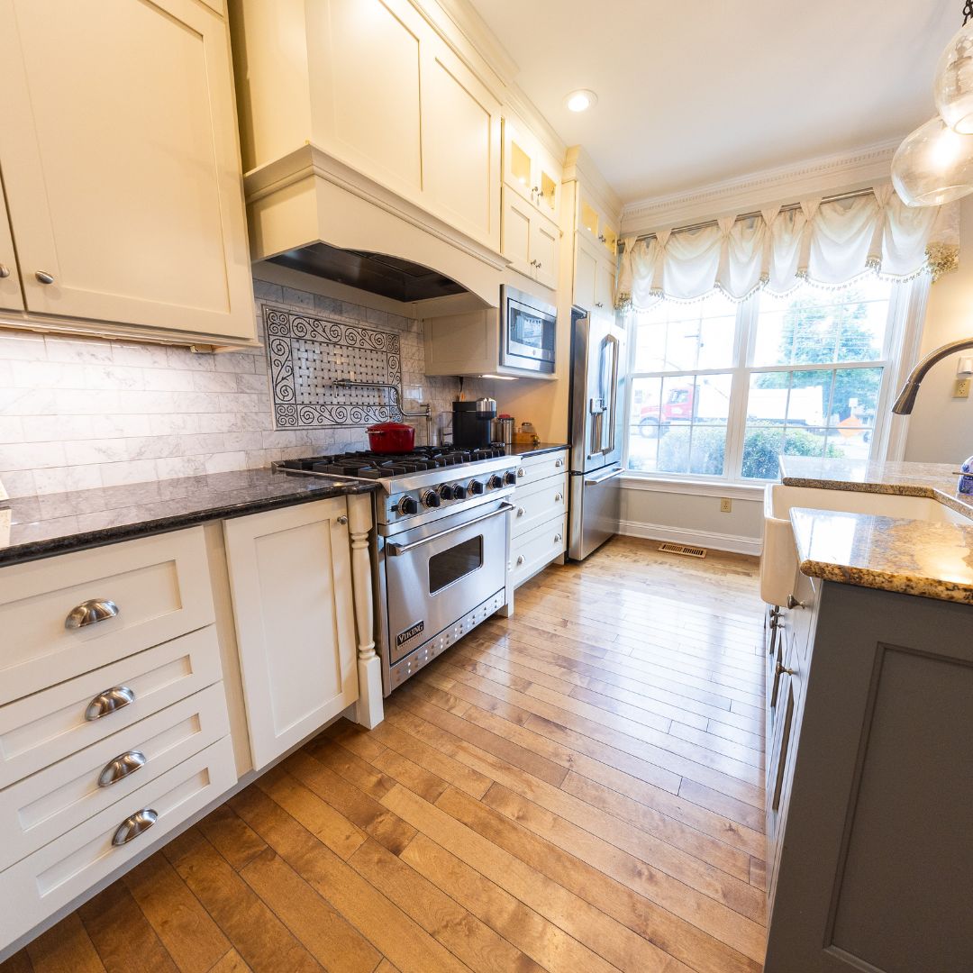 Full view of remodeled kitchen featuring stainless appliances, custom cabinetry, and large sunlit windows.