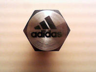 Annealed part marking example. 1 of 150,000 bolts with the Adidas logo marked on the head for an Adidas trade show booth.
