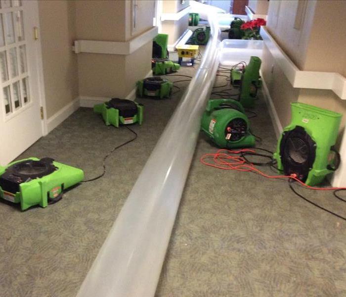 This is a large operation put together to circulate the air flow throughout an entire building. The tube that lays all the way down the hallway is blowing warm air into every room to ensure the structure dries evenly.