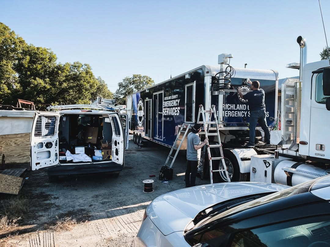 SimpleCom technicians installing network equipment and connectivity systems on an emergency services vehicle.