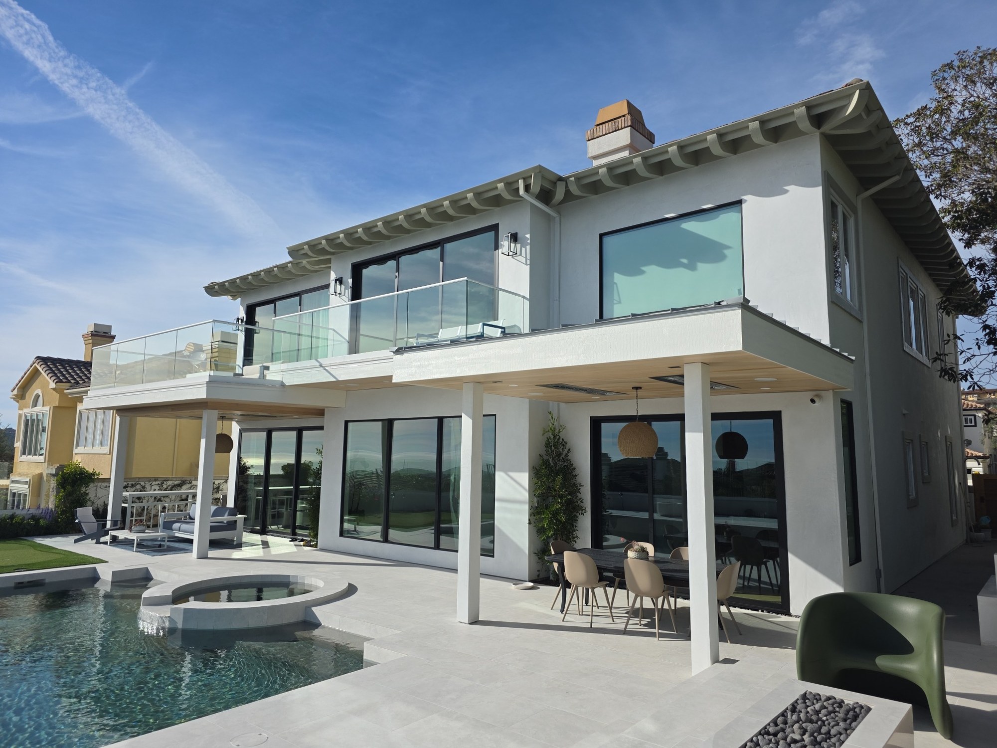 Exterior remodeling project featuring a modern two-story home, covered patio, and pool area. 