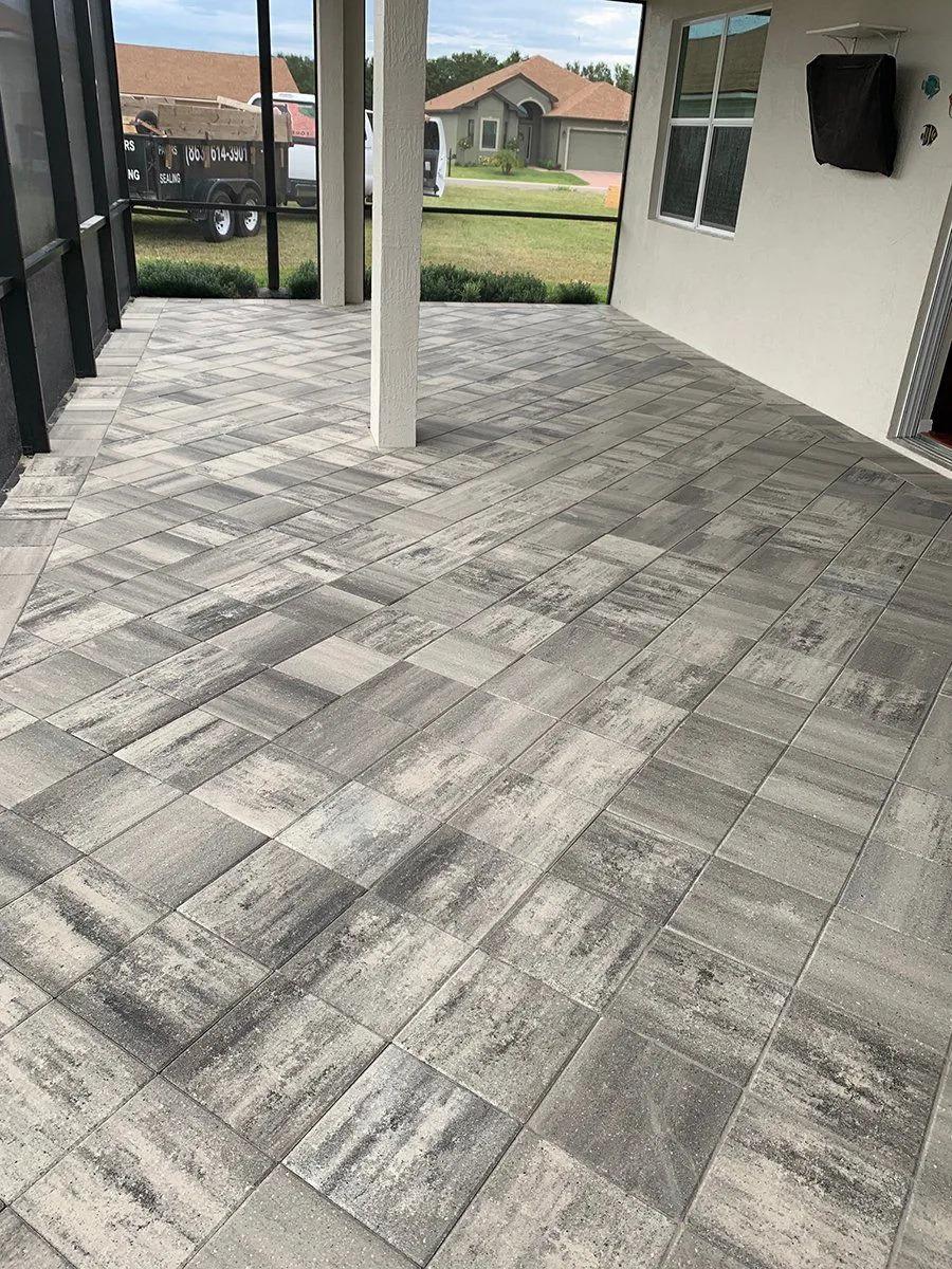 A Haines City home gave new life to their porch flooring by having  a variegated grey paver laid to replace standard concrete