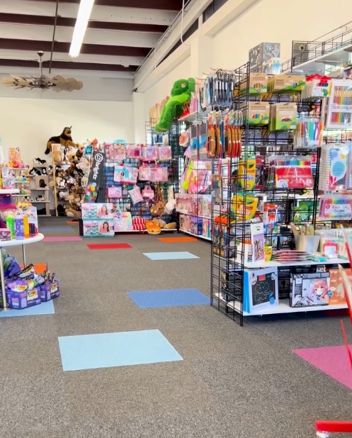 The bright and colorful interior of Little Lincoln's Toy Shop in Central Illinois featuring well-stocked toy shelves, plush displays, and cheerful floor tiles