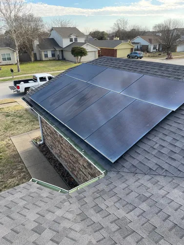 Modern solar panels are professionally installed on an asphalt shingle roof, enhancing residential energy efficiency while maintaining a clean appearance and maximizing renewable energy production throughout the year.