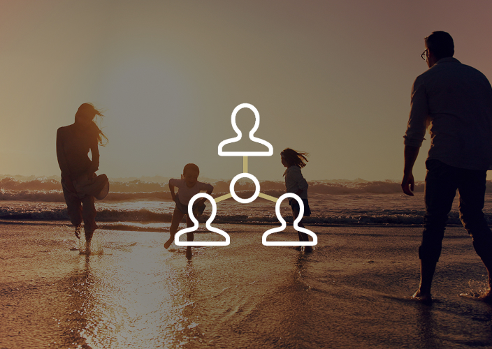 Family of four playing on the beach at sunset.