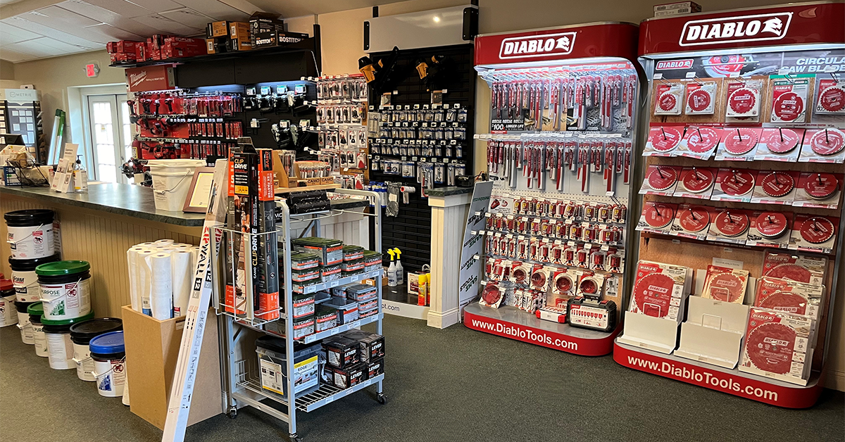 Retail display area with multiple Diablo-branded tool racks showcasing circular saw blades, drill bits, and accessories, with additional hardware products and supplies on shelves nearby.