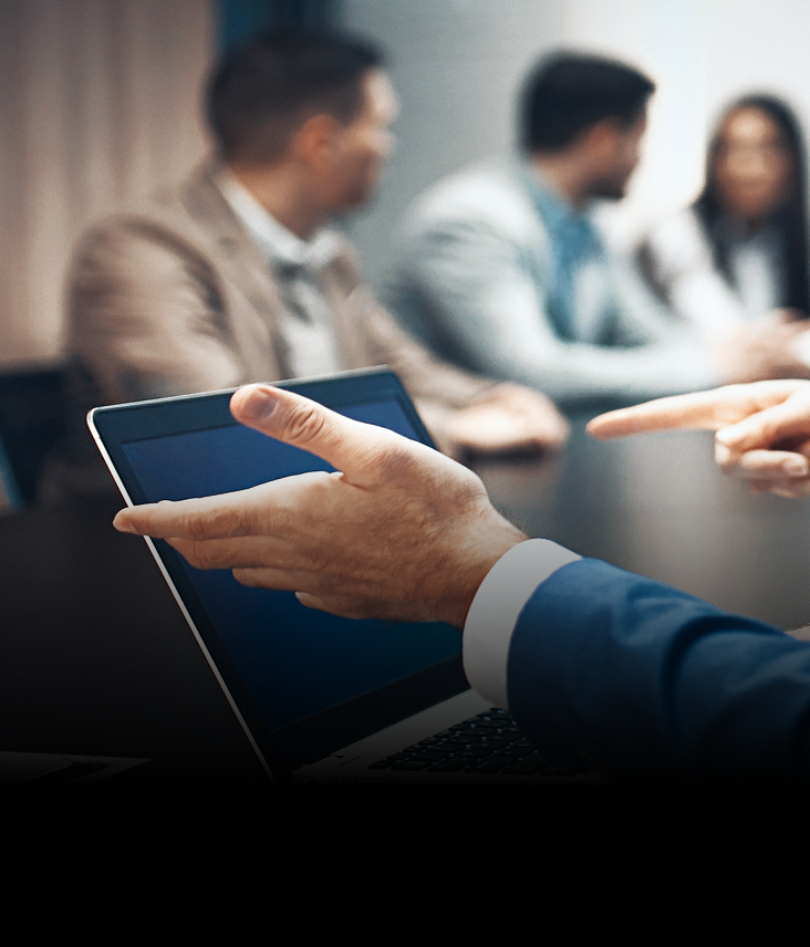 Close-up of a professional working on their laptop during a meeting.