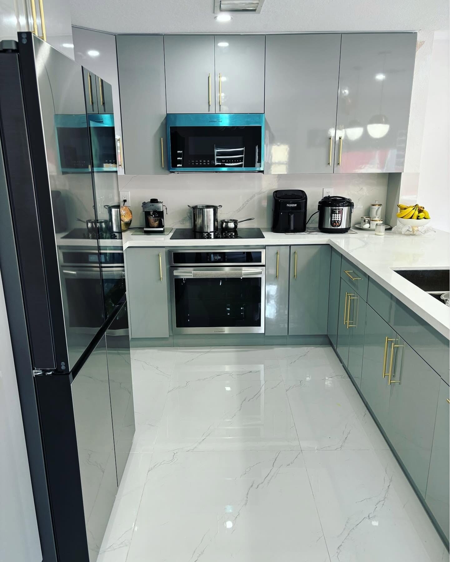 Remodelación de cocina de concepto moderno con gabinetes de alto brillo en dos tonos (gris claro y a 