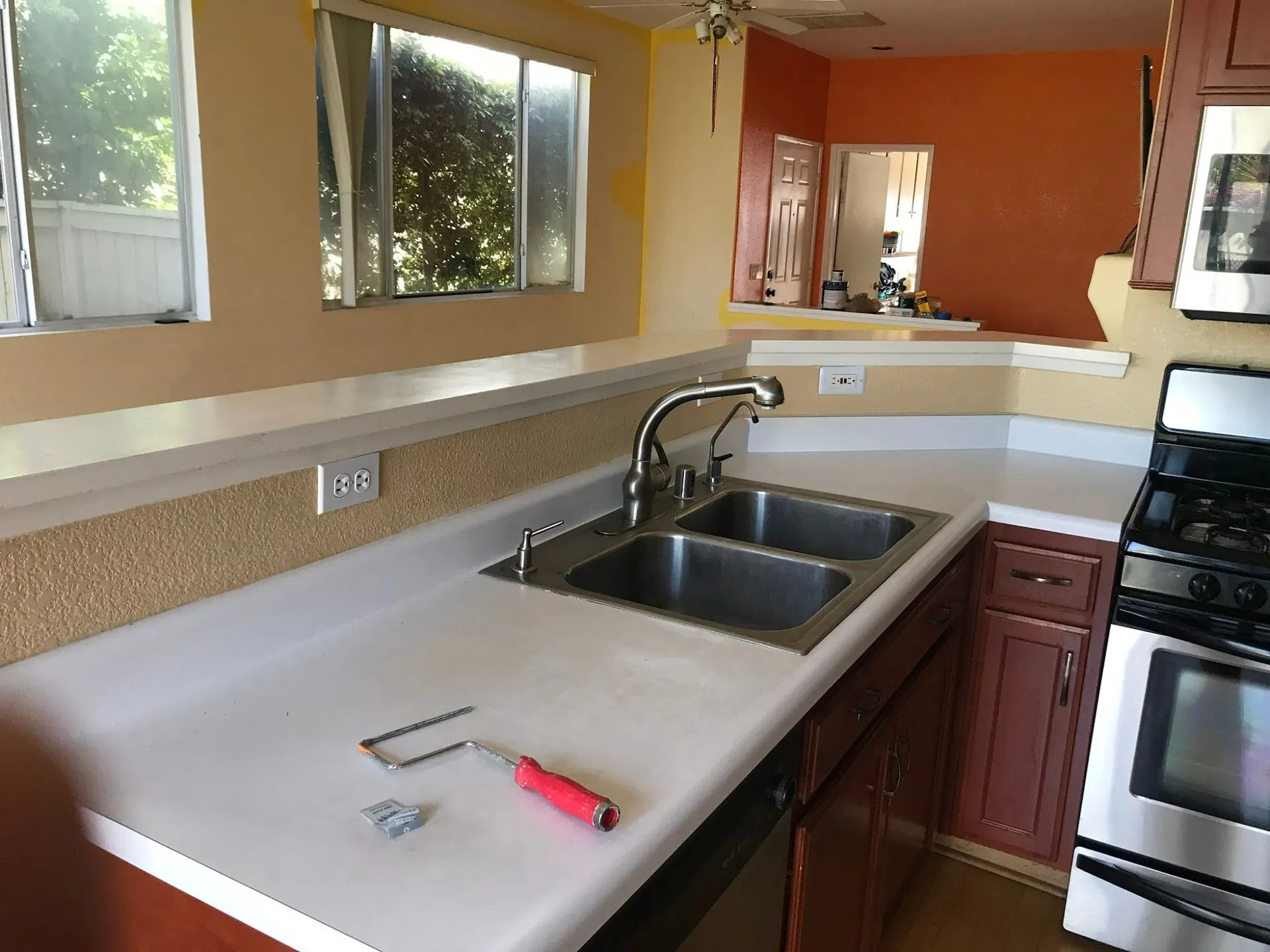 Kitchen before renovation featuring laminate countertops, double-basin sink, wood cabinetry, and pre 