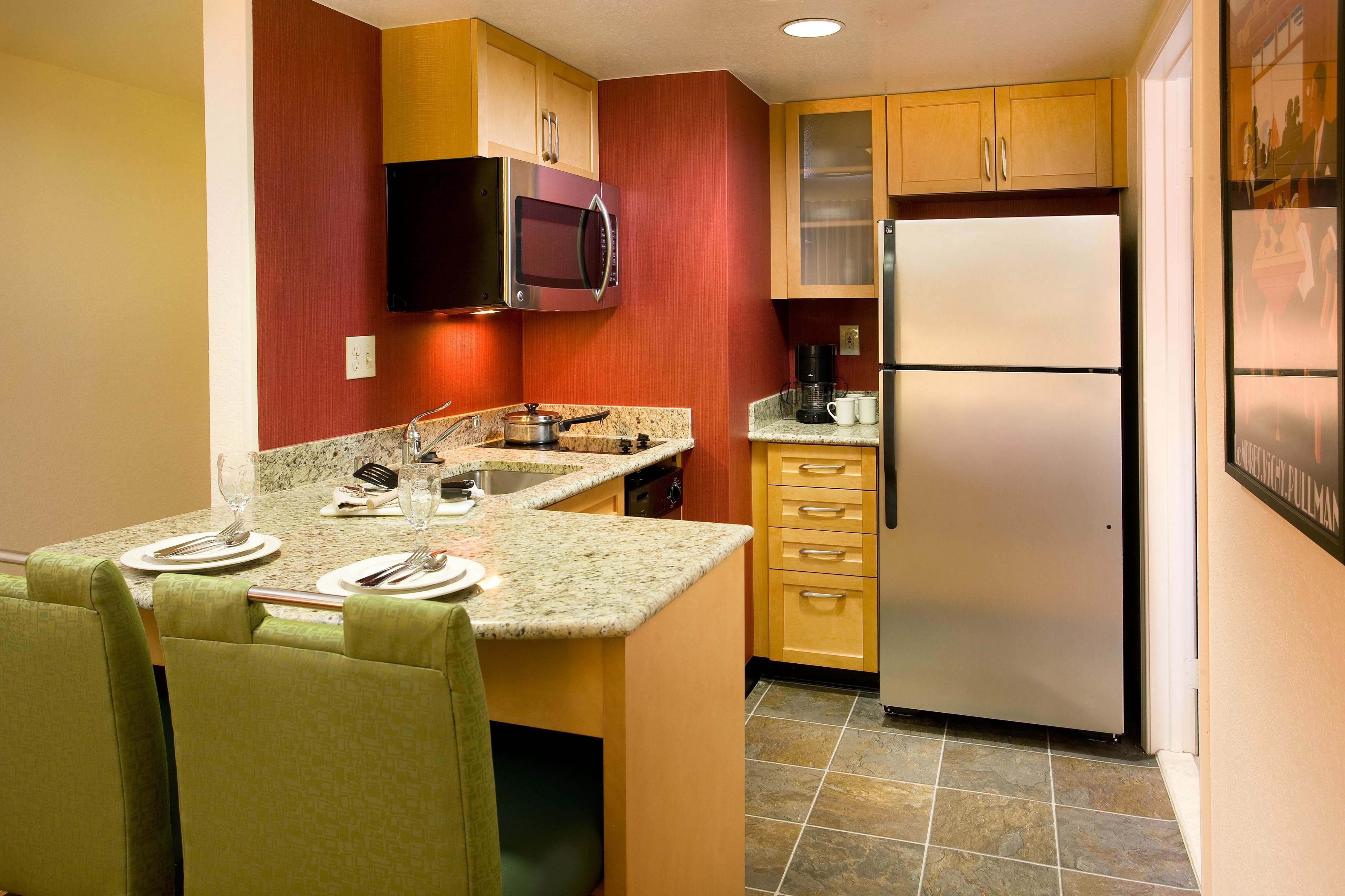 One-Bedroom Suite Kitchen - Kitchens in our one-bedroom suites feature a refrigerator, stove, microwave, toaster, pots, pans, dishes, silverware, glassware and dishwasher so you feel right at home.