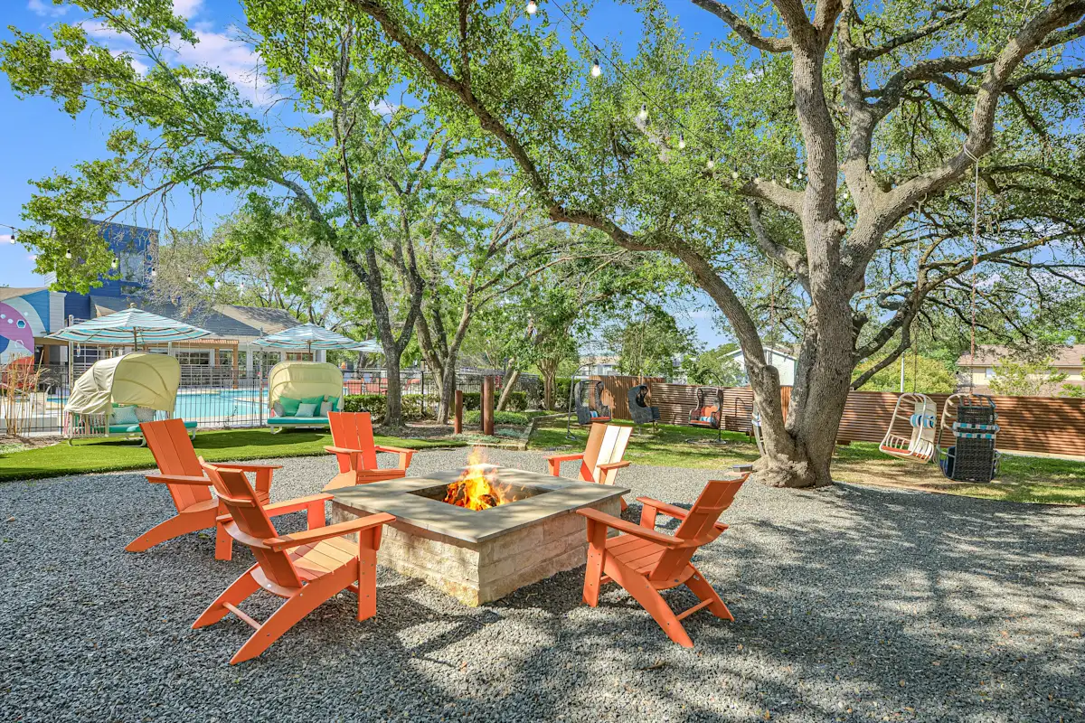 a patio with a fire pit and chairs around it