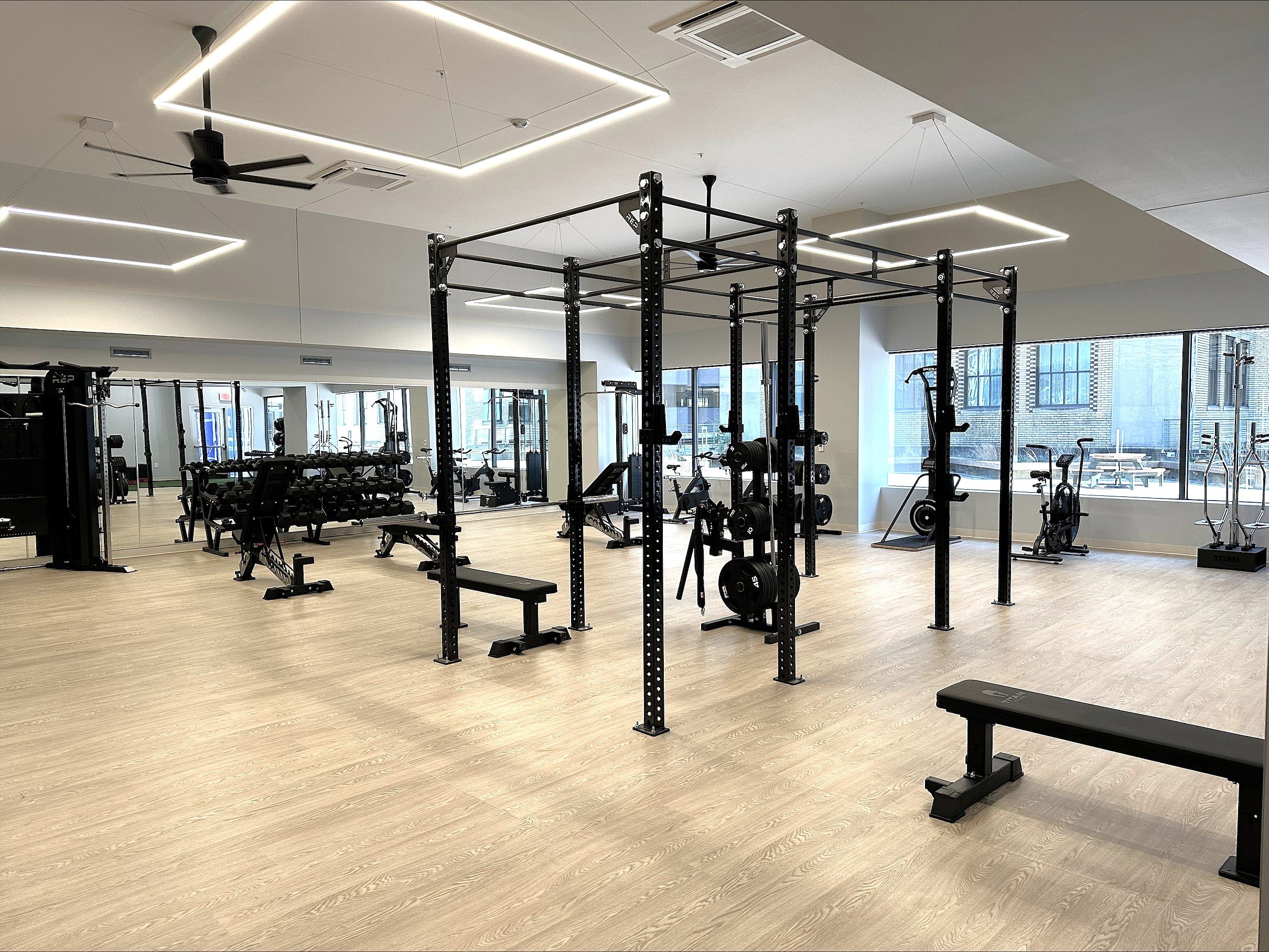 A gym with a variety of equipment including weightlifting machines and benches