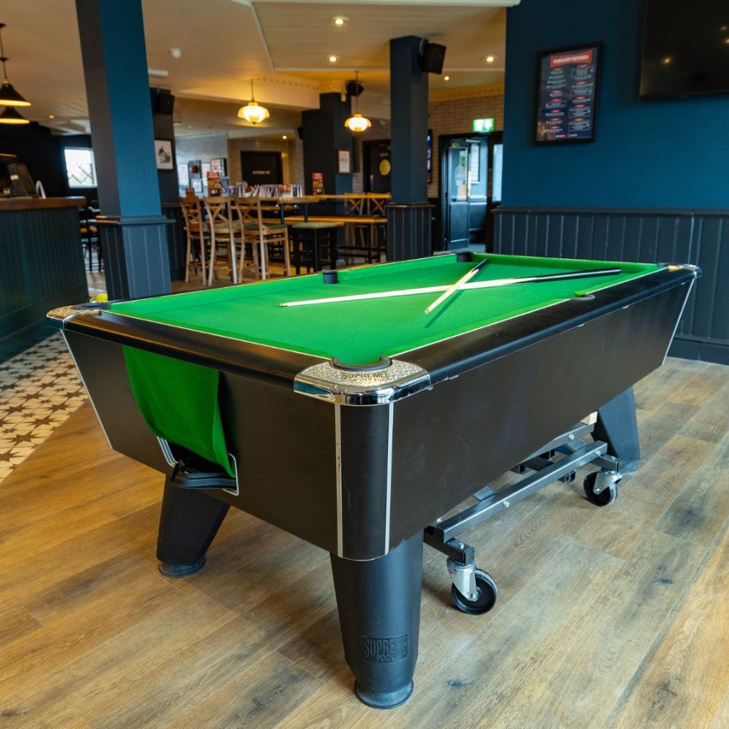 Central pool table within an open seating space, perfect for casual games and socialising.