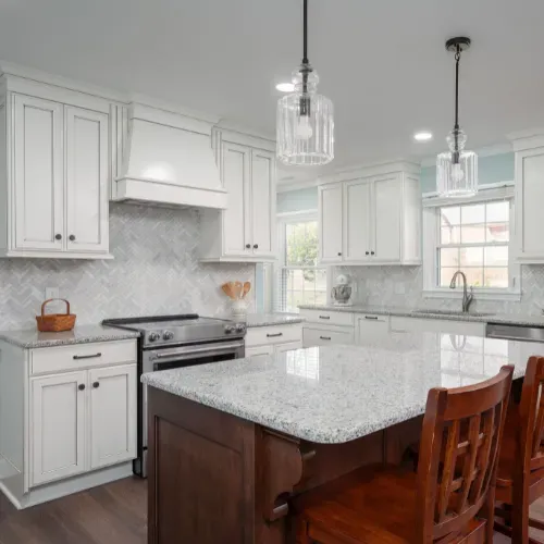 Luxury kitchen remodel near Badin Lake, North Carolina featuring custom white cabinetry, quartz countertops, pendant lighting, and a large center island. This kitchen renovation showcases high-end finishes and expert residential remodeling craftsmanship.