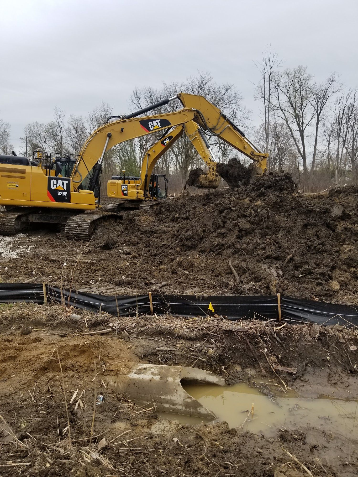 Heavy excavators perform earthmoving activities on a construction project. Operators remove soil and debris while preparing the site for utility installation, grading, and infrastructure development.