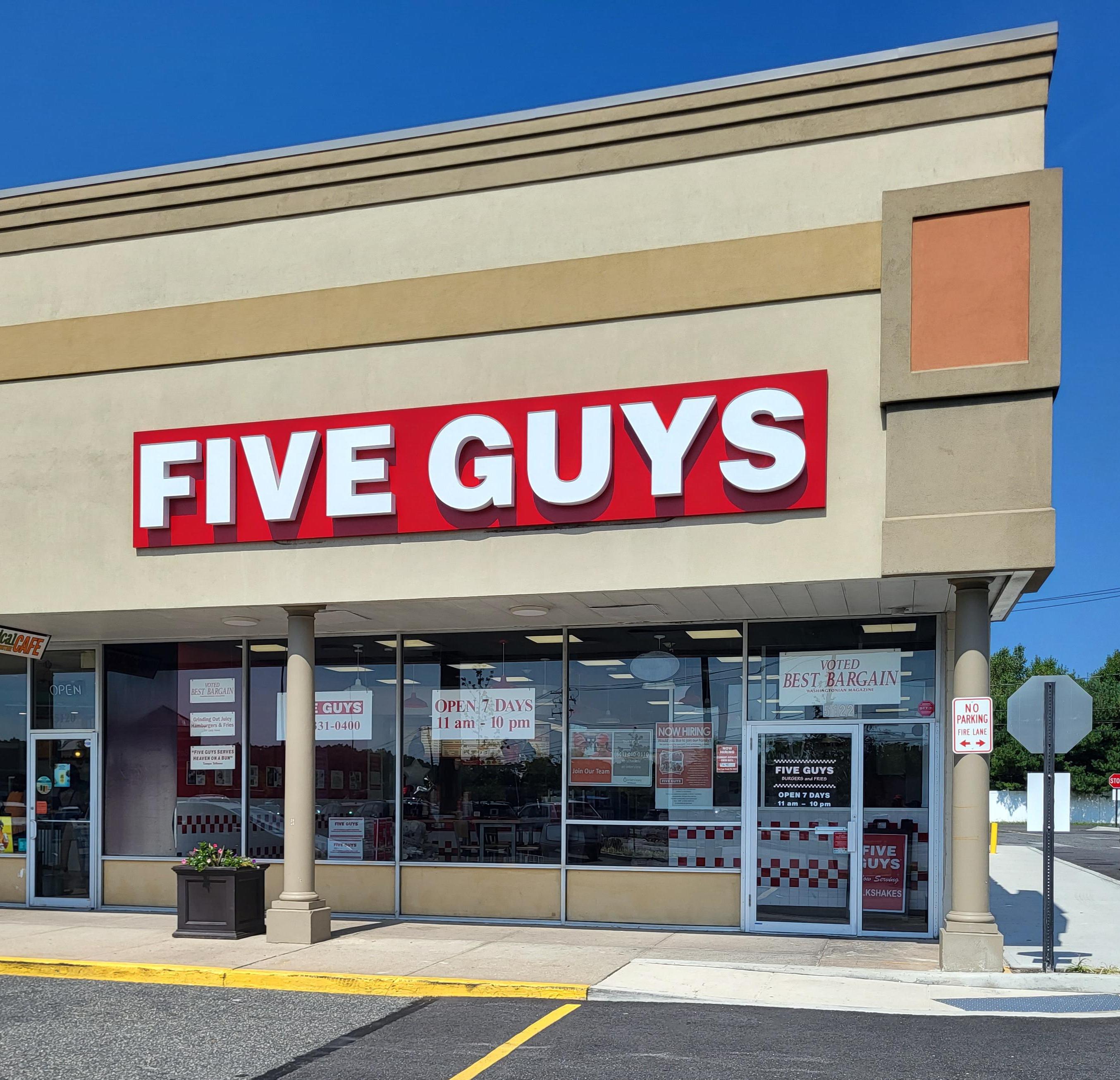 Exterior photograph of the Five Guys restaurant at 5122 Nesconset Highway in Port Jefferson Station, New York.