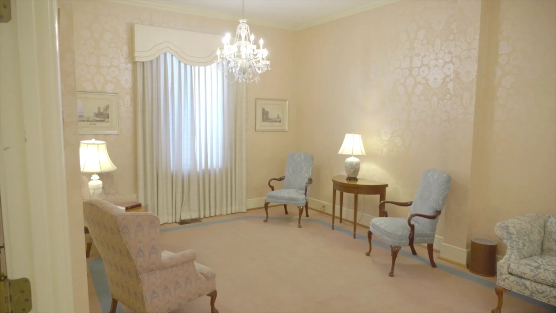 An arrangement room at Platt's Augusta, decorated with patterned wallpaper, a crystal chandelier, an 