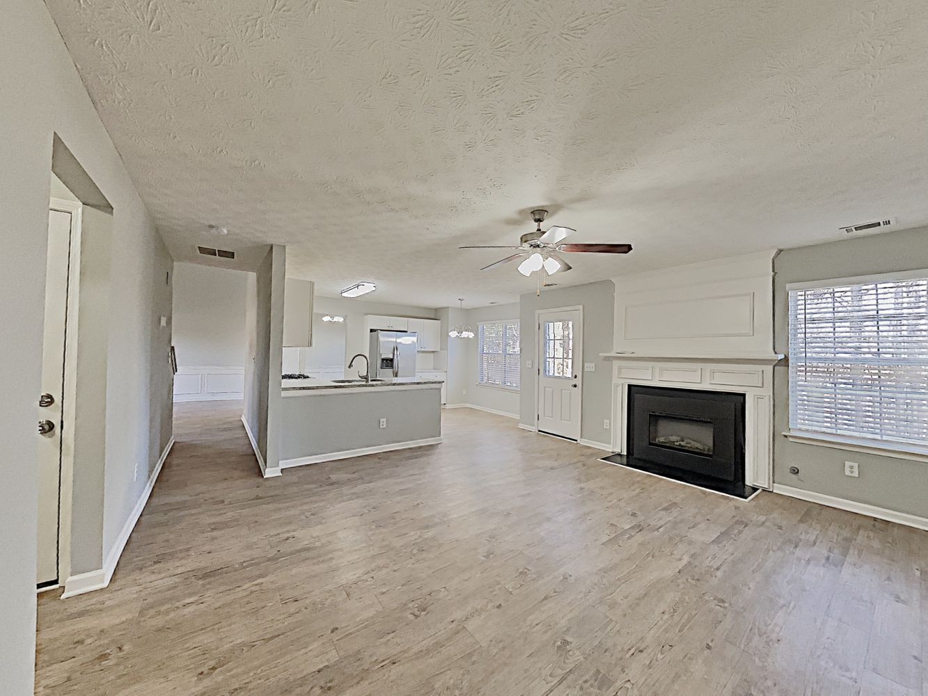 Spacious living space with modern flooring and a cozy fireplace at Invitation Homes Atlanta.