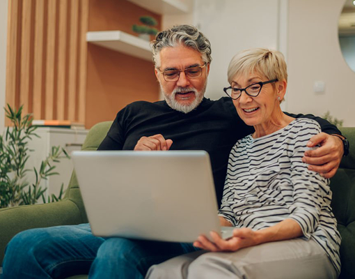 An older couple looking at a laptop together.