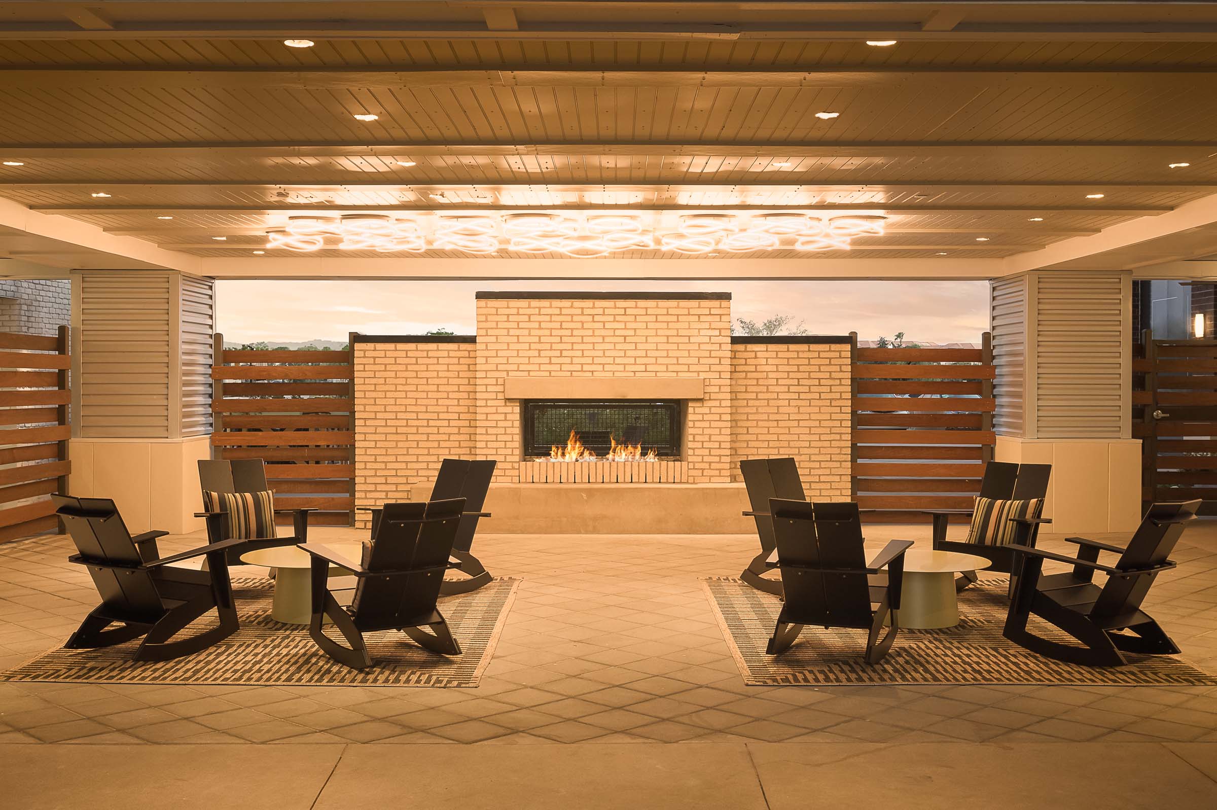 Covered outdoor lounge with fireplace and seating at Camden Gilbert apartment homes in Gilbert, AZ