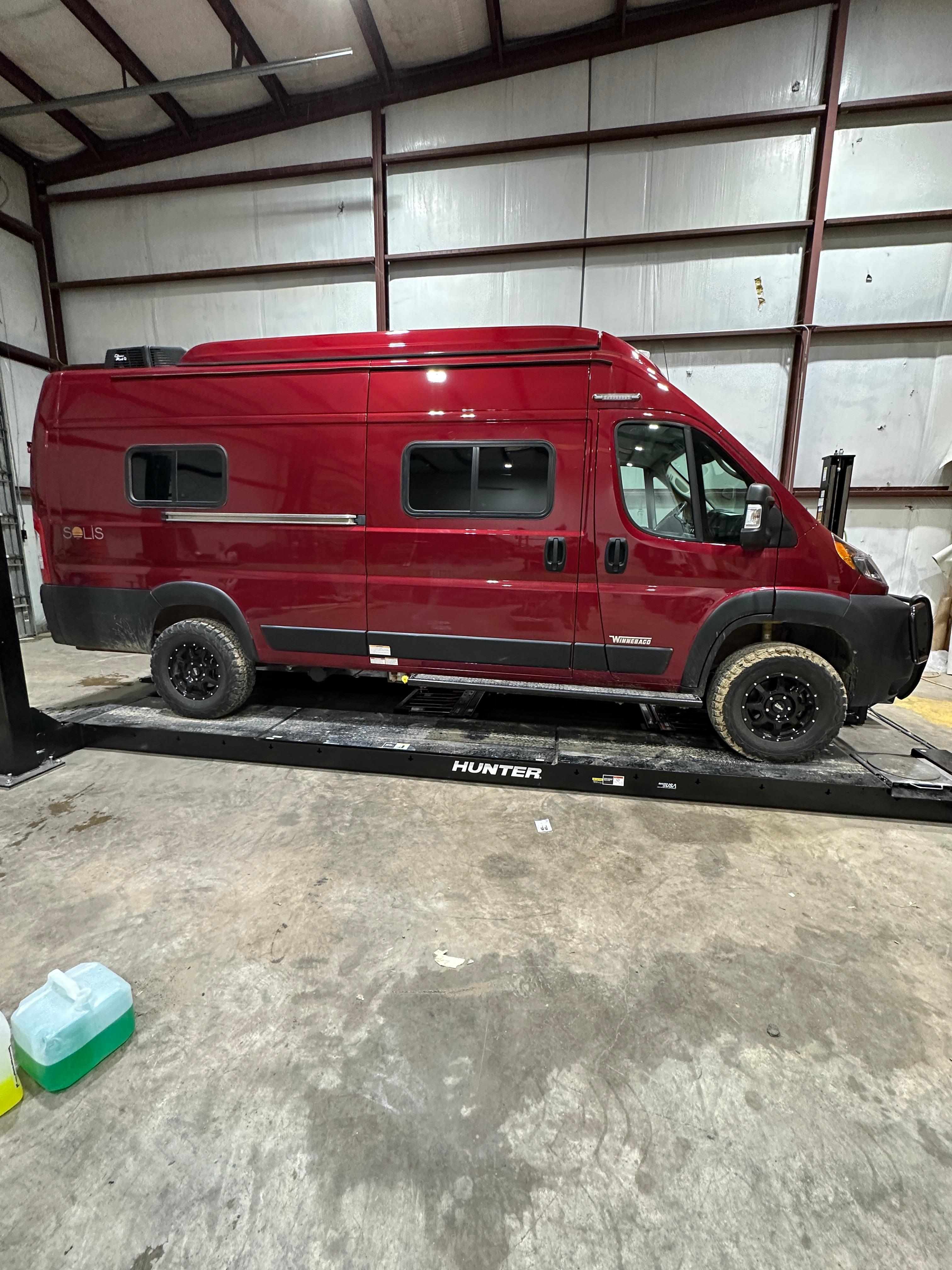 Winnebago Solis 59PX with lift kit, front bumper, Method Wheels, and custom steps installed on a Promaster van chassis.