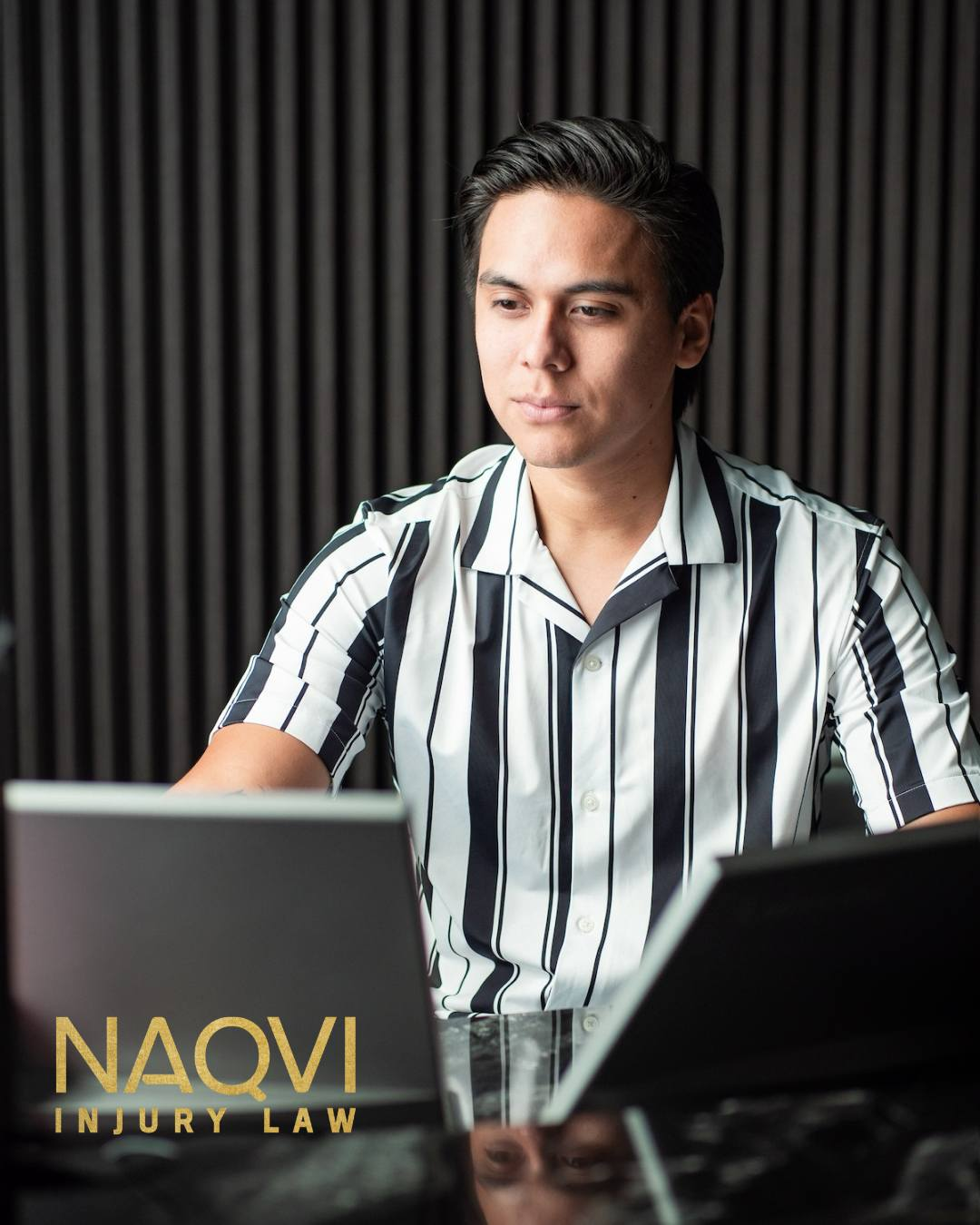 Naqvi Law team member sitting at desk