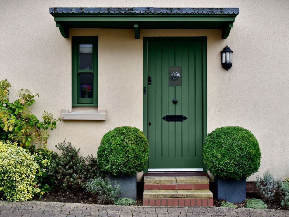 A wooden, panelled front door that has been painted green,